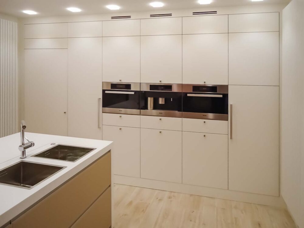 Cuisine avec îlot en verre blanc mat, colonnes en laqué mat et plan de travail en Corian blanc