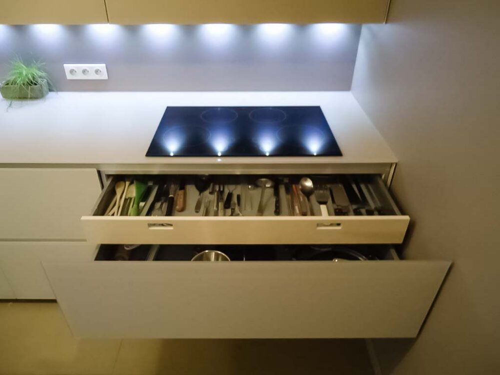 Cuisine en verre beige et blanc avec colonnes suspendues. Éléments en plaquage bois - tiroir haut de gamme