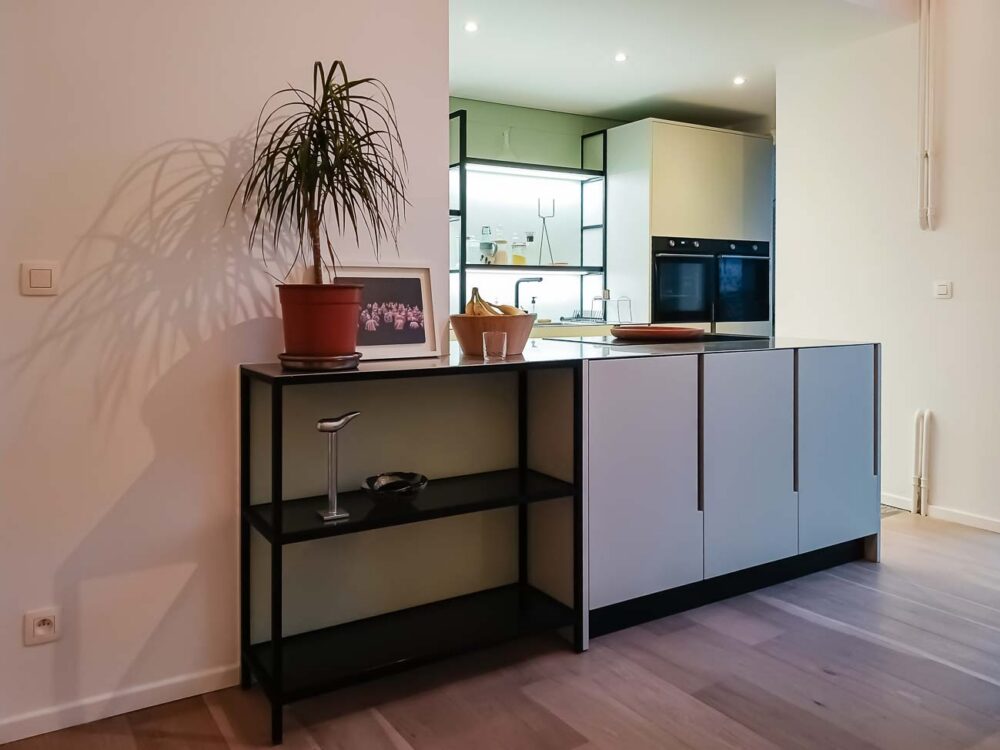 Cuisine laqué mat vert pastel lumineuse et étagères structurées, plan de travail en acier inoxydable