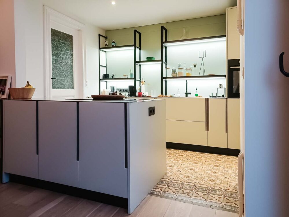 Cuisine laqué mat vert pastel lumineuse et étagères structurées, plan de travail en acier inoxydable