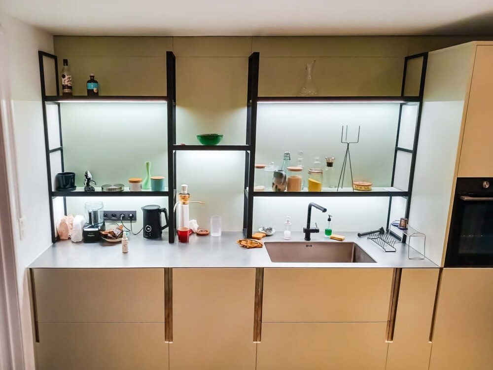 Cuisine laqué mat vert pastel lumineuse et étagères structurées, plan de travail en acier inoxydable