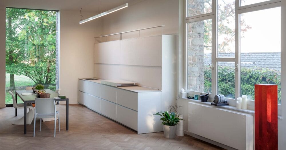 Cuisine en verre blanc mat et colonnes laqué mat gris suspendues