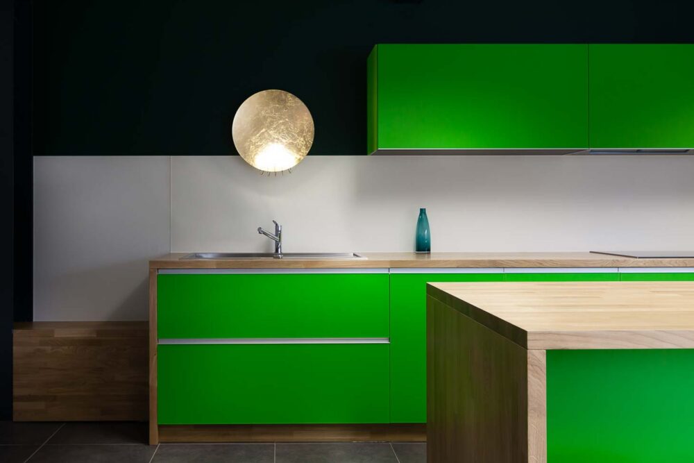 Cuisine d’entreprise en verre vert et bois massif, avec luminaires et salle de réunion