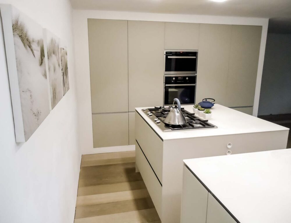 Cuisine avec trois îlots cubiques en verre couleur parchemin, colonnes et frigo américain intégré