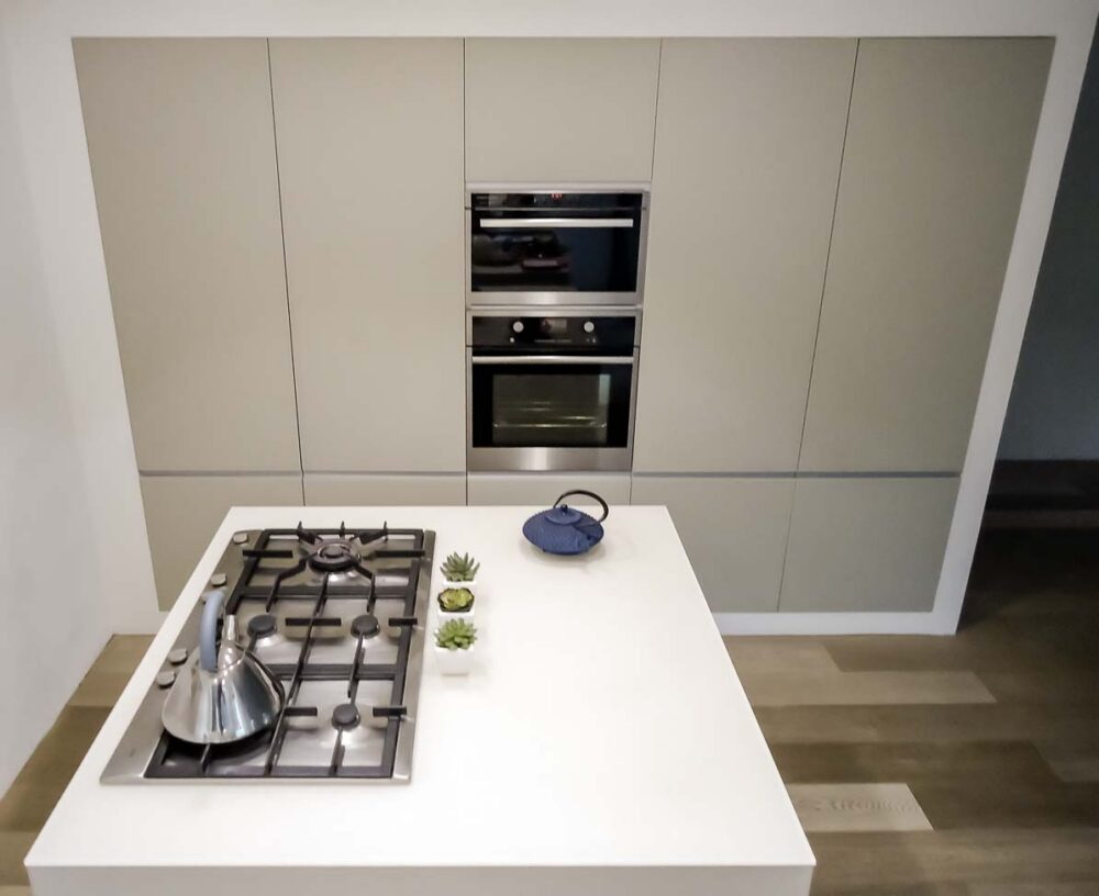 Cuisine avec trois îlots cubiques en verre couleur parchemin, colonnes et frigo américain intégré