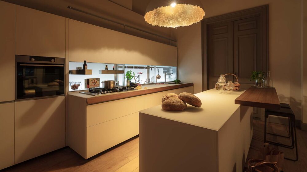 Cuisine en verre blanc, plaquage noyer et luminaire artisanal haut de gamme en Belgique par Vertical Design