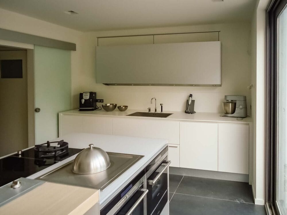 Cuisine avec îlot en verre blanc nuage, bois et aluminium