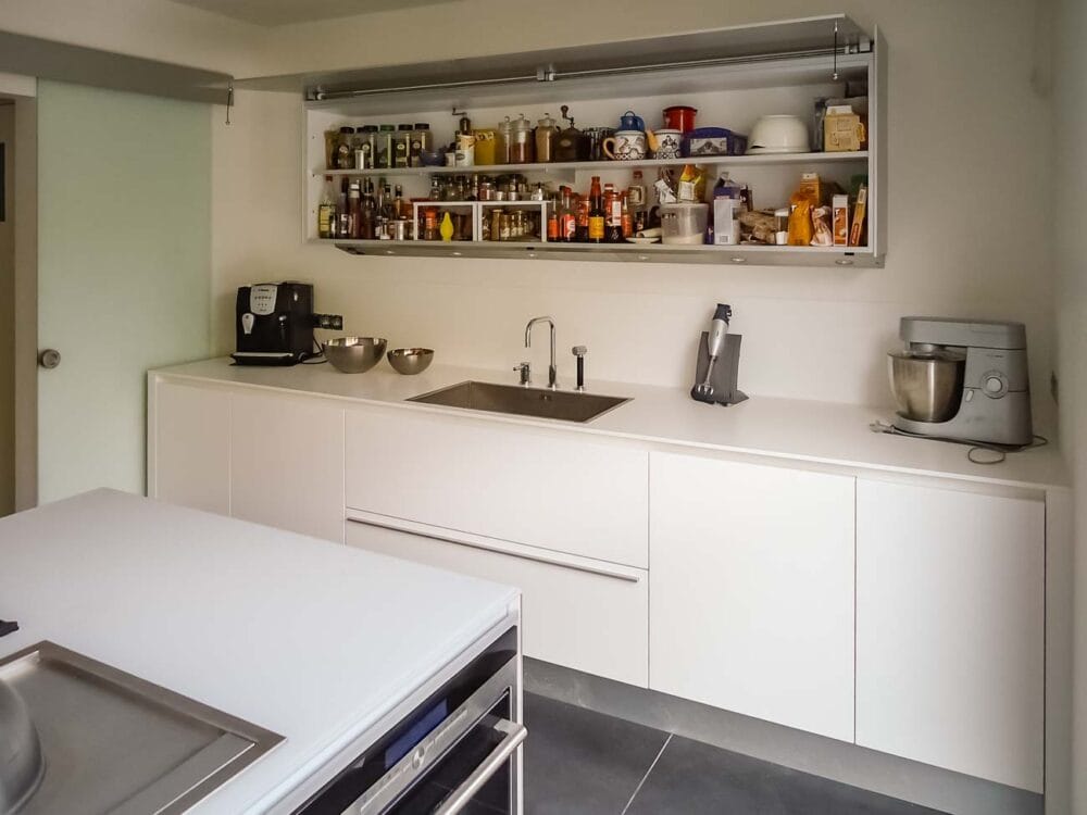 Cuisine avec îlot en verre blanc nuage, bois et aluminium