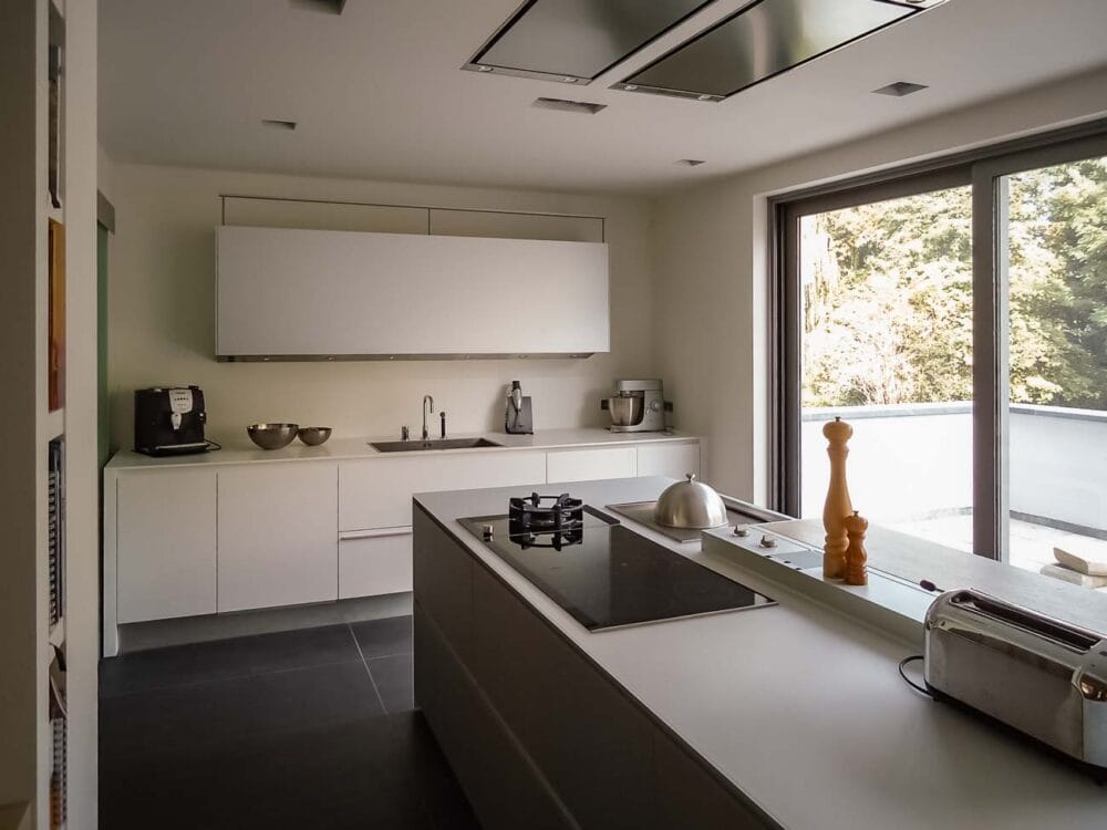 Cuisine avec îlot en verre blanc nuage, bois et aluminium