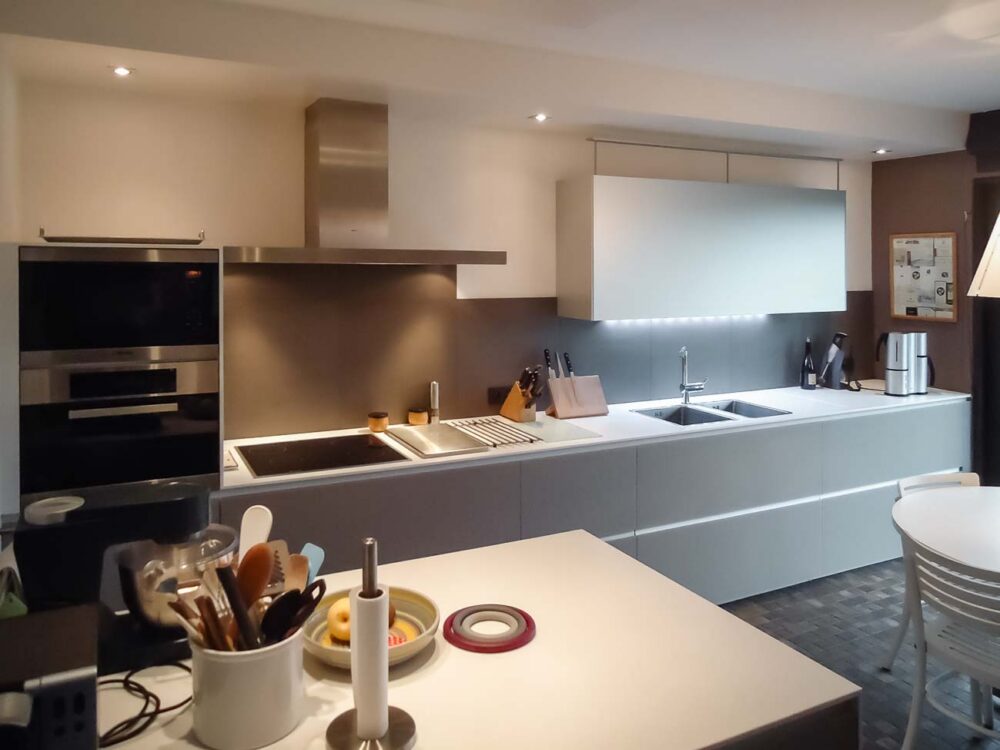 Cuisine en verre gris et plan de travail en Corian blanc sur mesure