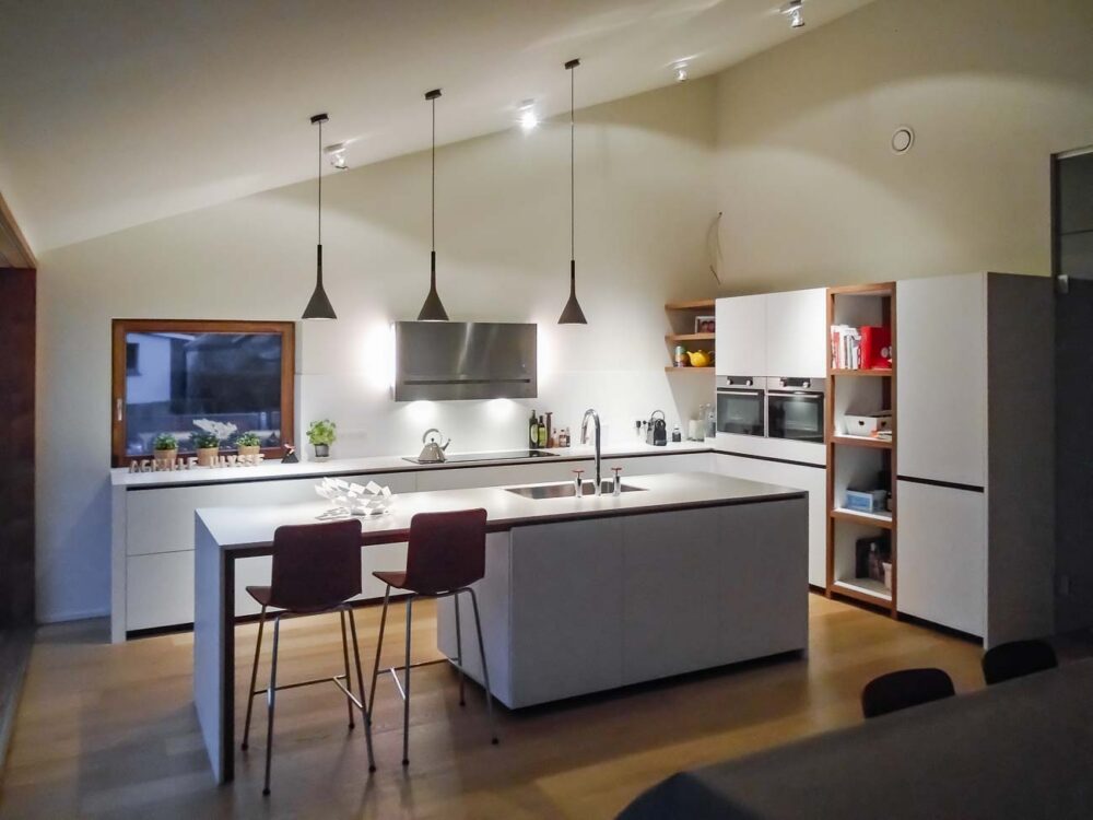 Cuisine laqué blanc mat, détails en noyer et plan de travail en Corian