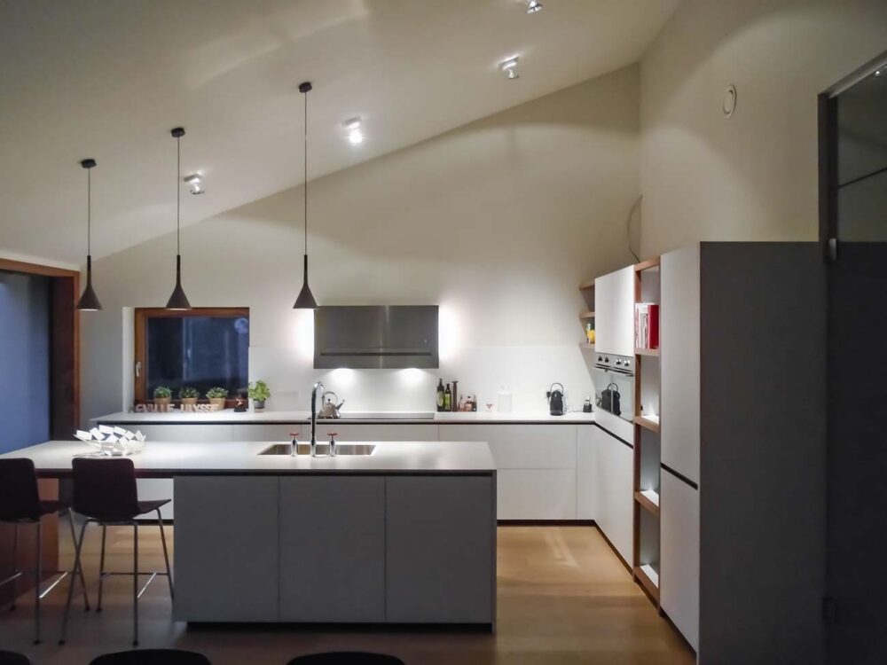 Cuisine laqué blanc mat, détails en noyer et plan de travail en Corian