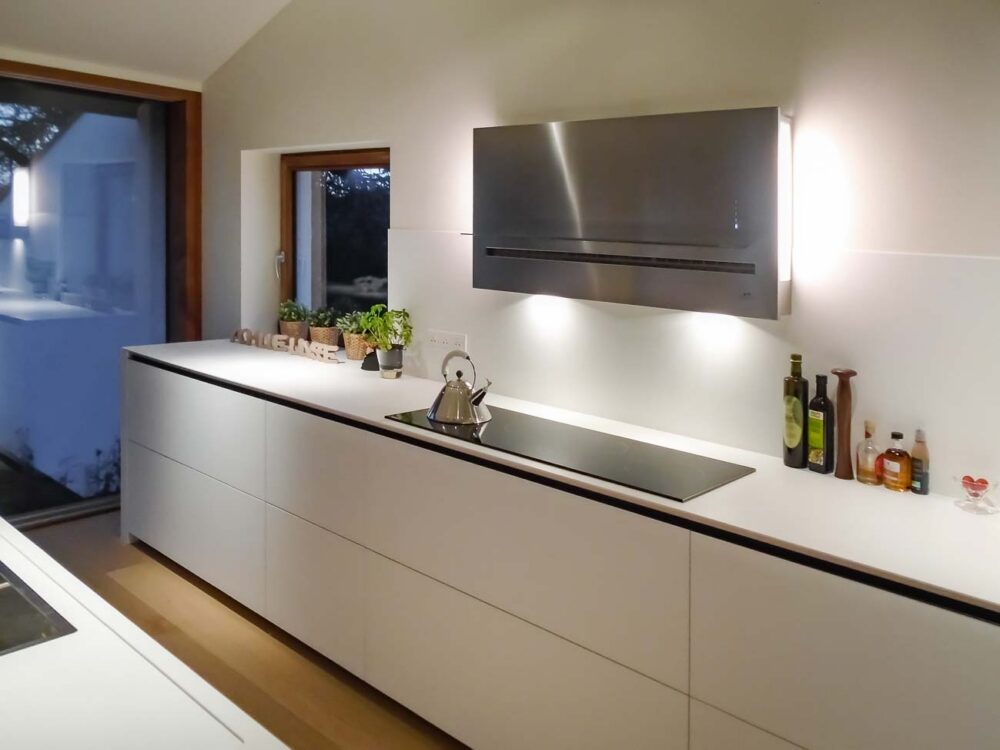 Cuisine laqué blanc mat, détails en noyer et plan de travail en Corian