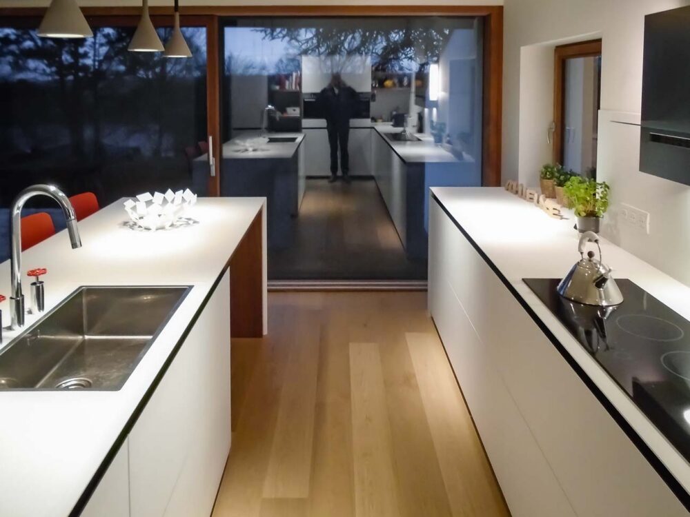 Cuisine laqué blanc mat, détails en noyer et plan de travail en Corian