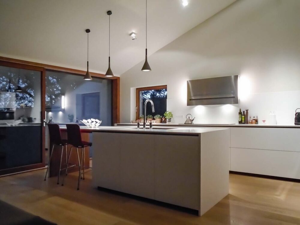 Cuisine laqué blanc mat, détails en noyer et plan de travail en Corian