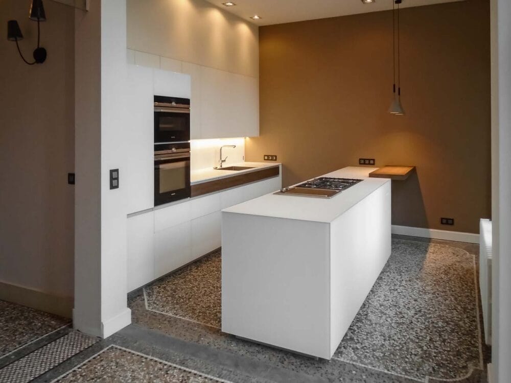 Cuisine avec îlot en verre blanc mat, compositions murales en laqué mat et détails en bois de noyer