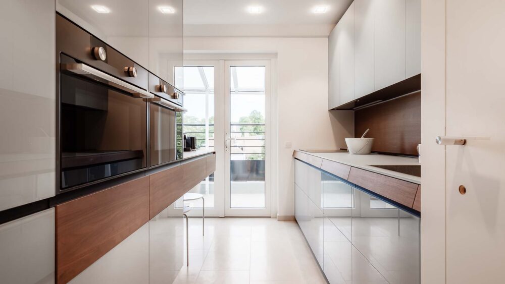 Cuisine en verre gris bleuté mat et brillant avec plaquage bois, noyer