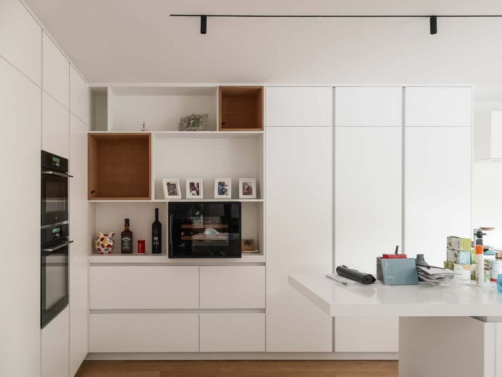 Cuisine design minimaliste blanche laqué mat, plan de travail en Corian blanc bords épais avec meubles personnalisés
