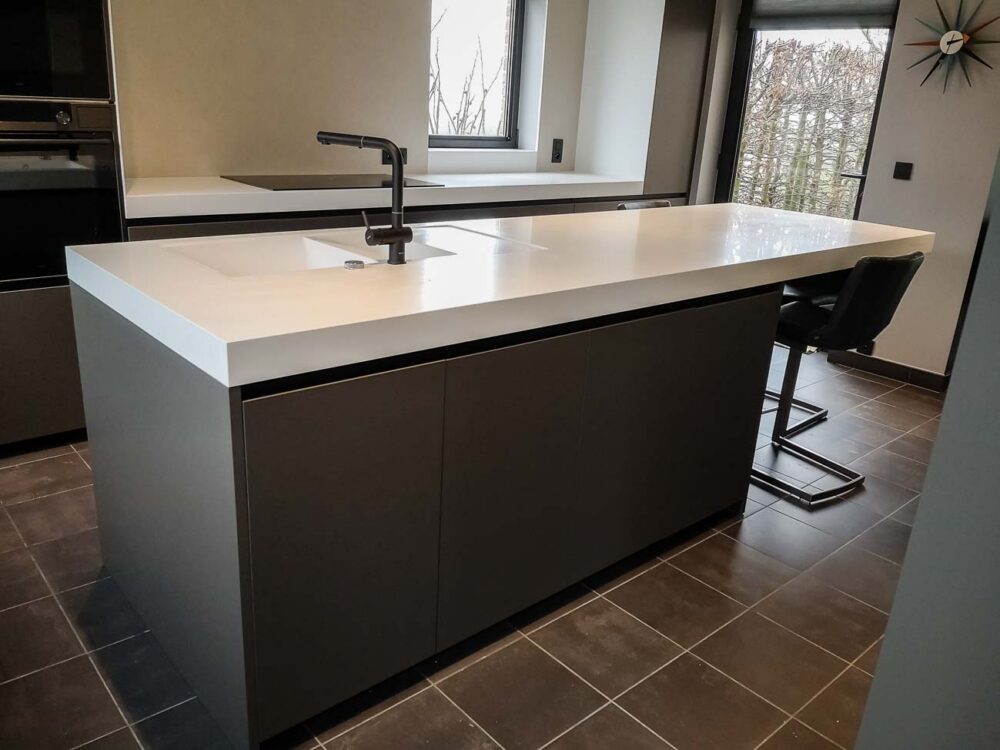 Cuisine laqué mat gris foncé, plan de travail en Corian blanc à bords épais