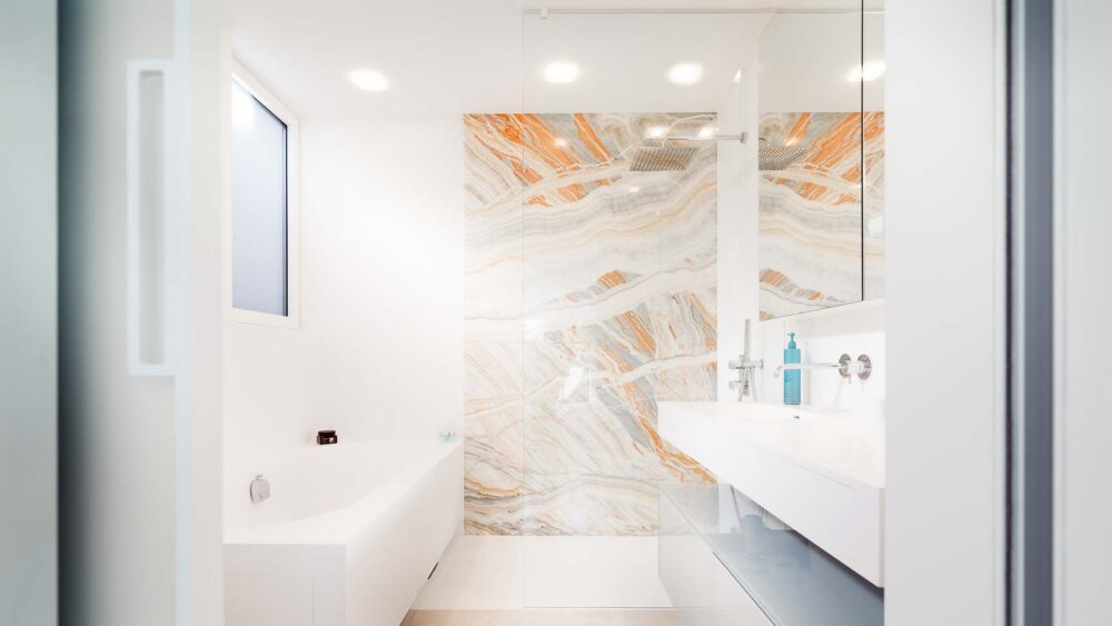 salle de bain avec tub de douche sur mesures en Corian à fleur, baignoire entièrement en Corian. Paroi de douche en pierre naturelle Onyx avec meubles suspendus haut de gamme en verre.